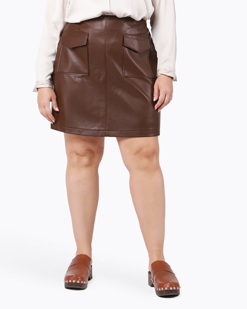 Front of a model wearing a size 0X Rylan Faux Leather Mini Skirt in Brown by DEX PLUS. | dia_product_style_image_id:235432